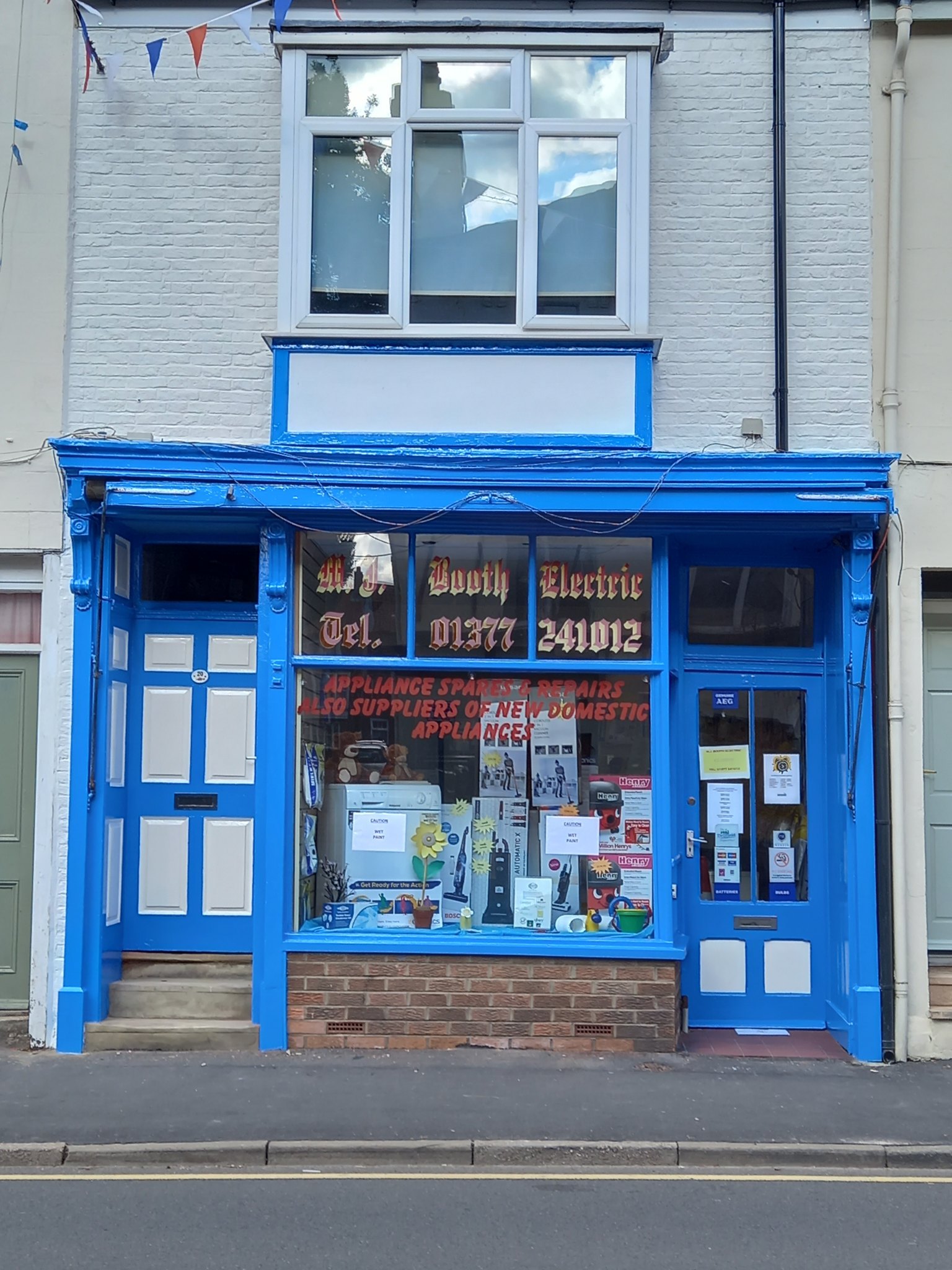 The blue-painted shopfront of M J Booth Electric on Middle Street North, Driffield, with gold lettering on the windows
