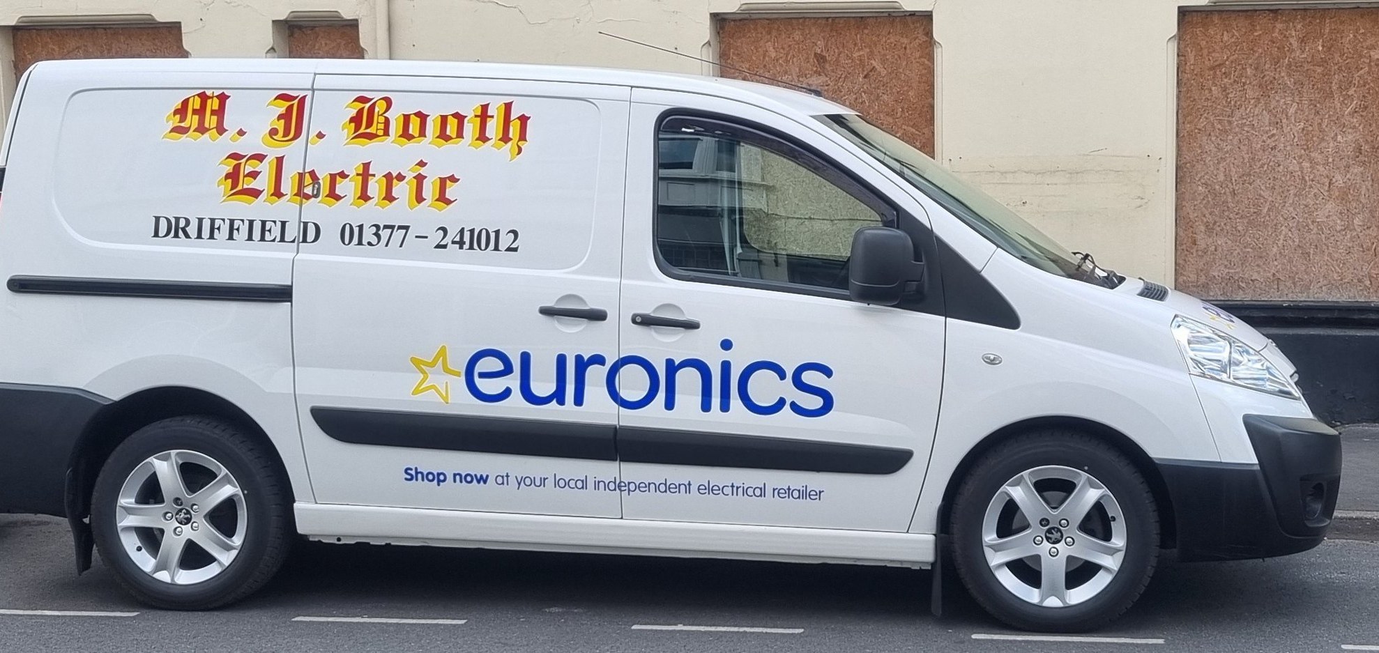 The M J Booth Electric delivery van, white with gold lettering and the shop's Driffield phone number